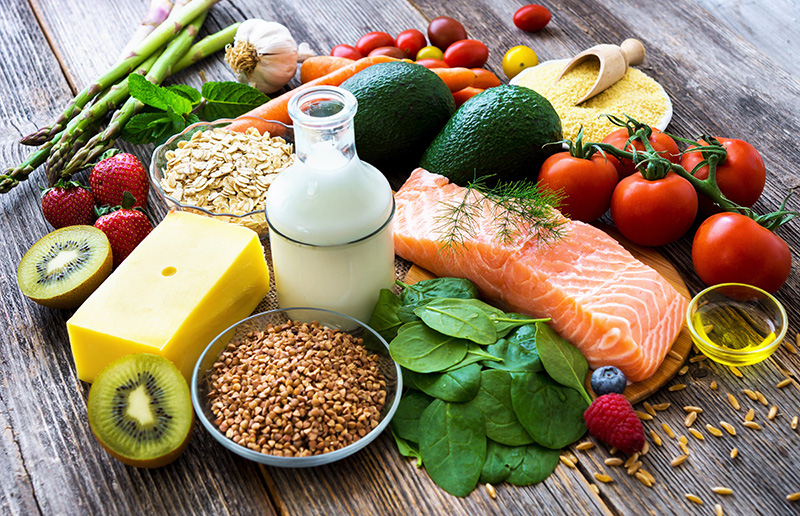 Table with a variety of healthy foods, including vegetables, nuts, and grains, for balanced nutrition.